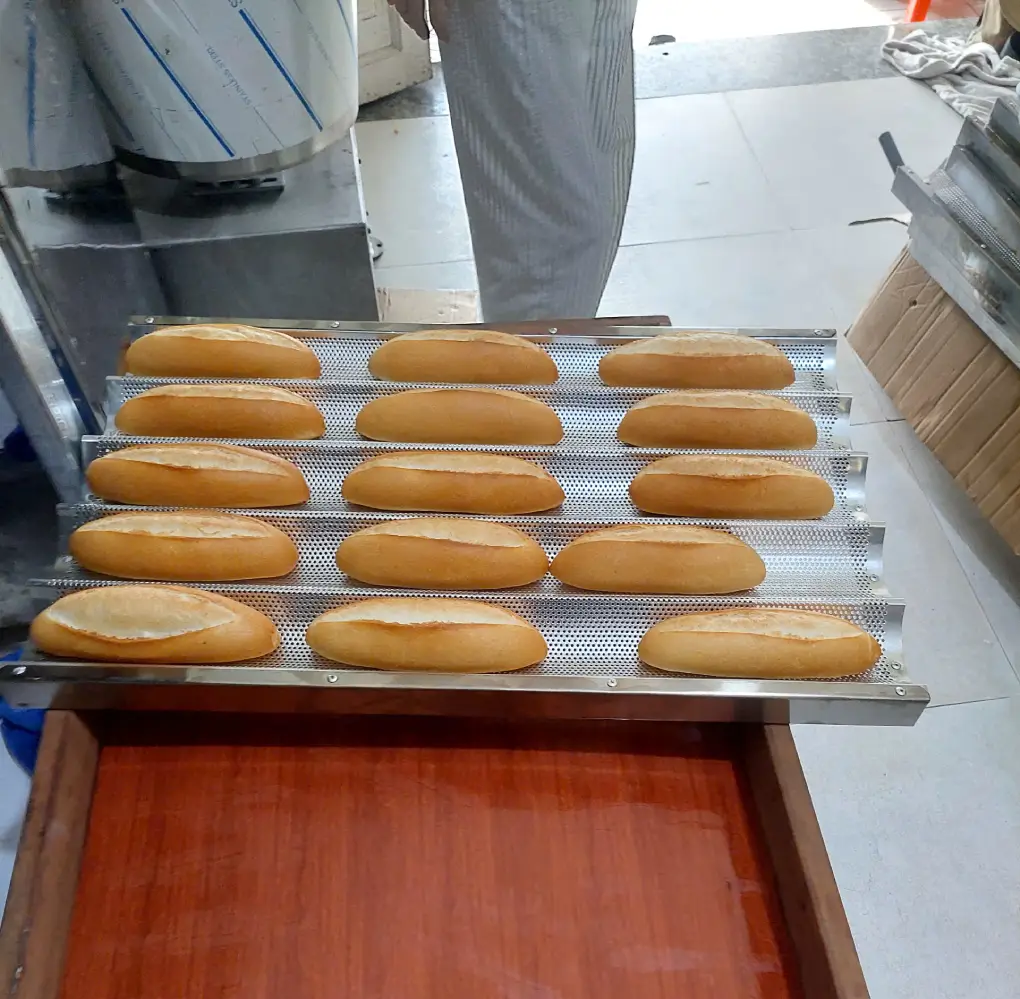 Cận cảnh các ổ bánh mì vỏ vàng, đường rạch nở trên khay nướng tại cửa hàng Đông Hòa.